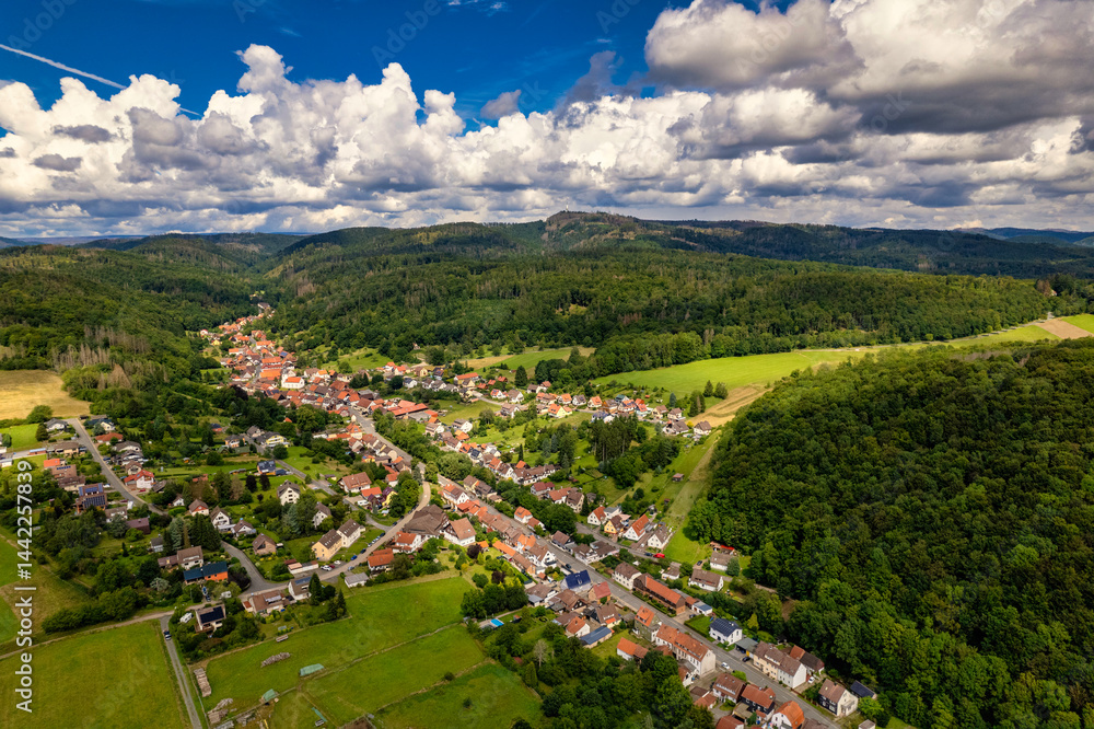 Vibrant German Village Nestled in a Valley Surrounded by Lush Greenery and Picturesque Mountains on a Bright Sunny Day