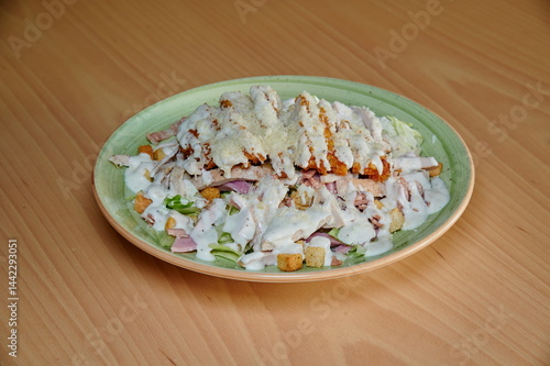 Obraz na płótnie A plate of food with a green plate and a white sauce. The food is chicken and vegetables w salonie