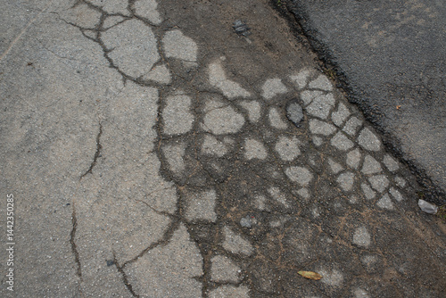 Foto Cracks and Deterioration on a Worn Asphalt Road Surface / 노후된 아스팔트 도로의 균열과 마모된 표