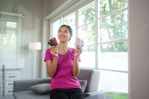 Free Download Happy young woman shops online from home using laptop and credit card, enjoying digital convenience, comfort, and secure mobile payments - GFXLoad