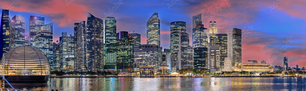 Naklejka premium Singapore CBD City Skyline on the river at Sunset with vibrant colours of the high-rise apartment and office towers with the beautiful colours of the sky. Panorama view of Singapore CBD buildings 