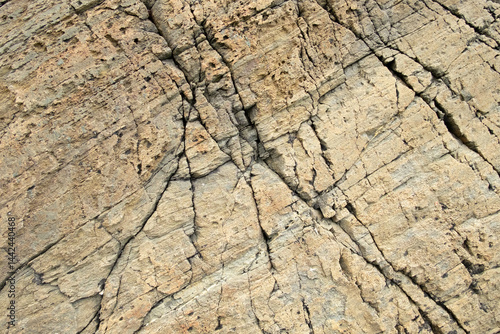 Closeup of grey-brown rock surface with cracks