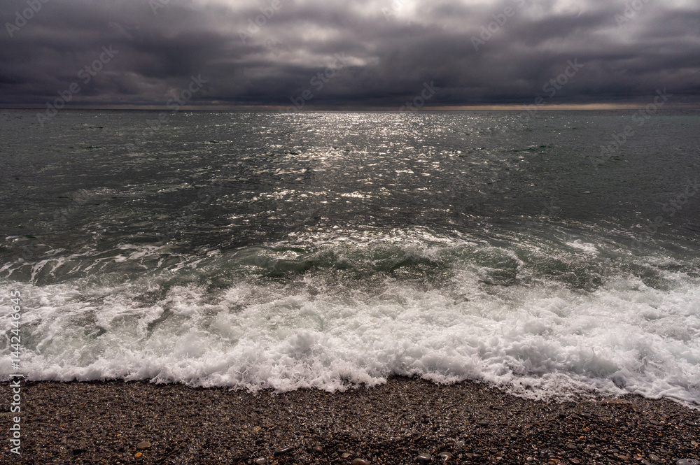 Dark storm clouds over ocean. Dramatic seascape. Clouds and rain flurry over sea.