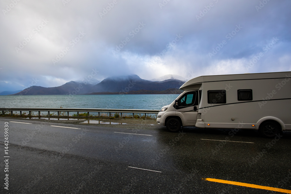 A motorhome parked by the road in the autumn landscape of the Lyngen Alps, Northern Norway, with mountains.