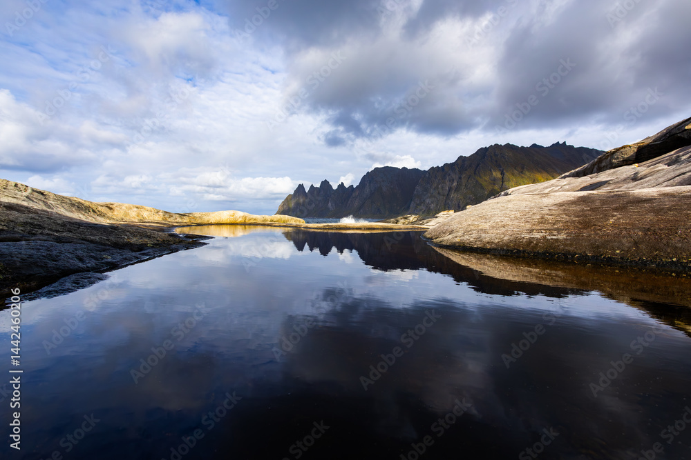 Autumn landscape of Senja Island in Northern Norway with colorful foliage, mountains, and a serene fjord.