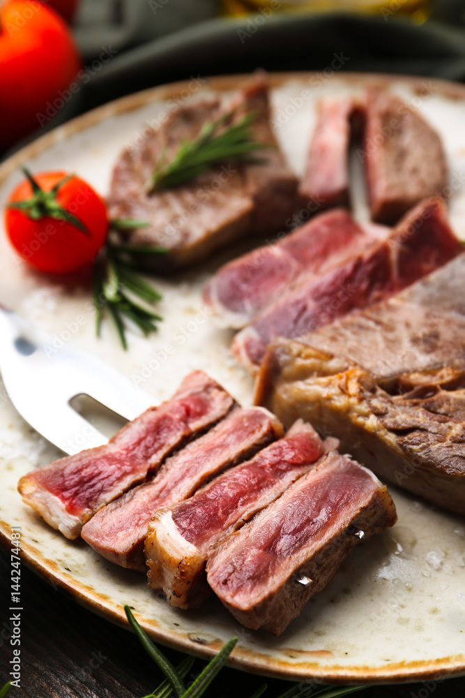 Pieces of delicious beef meat, spices and tomato on table, closeup Pieces of delicious beef meat, spices and tomato on table, closeup