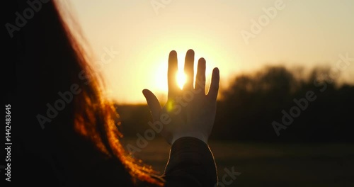 Dreaming girl silhouette reaches hand sun, symbolizing freedom and dreams. Dreaming girl stretches arm toward sunlight, silhouette shines with hope and aspiration, closeup dreaming girl in sunlight.
