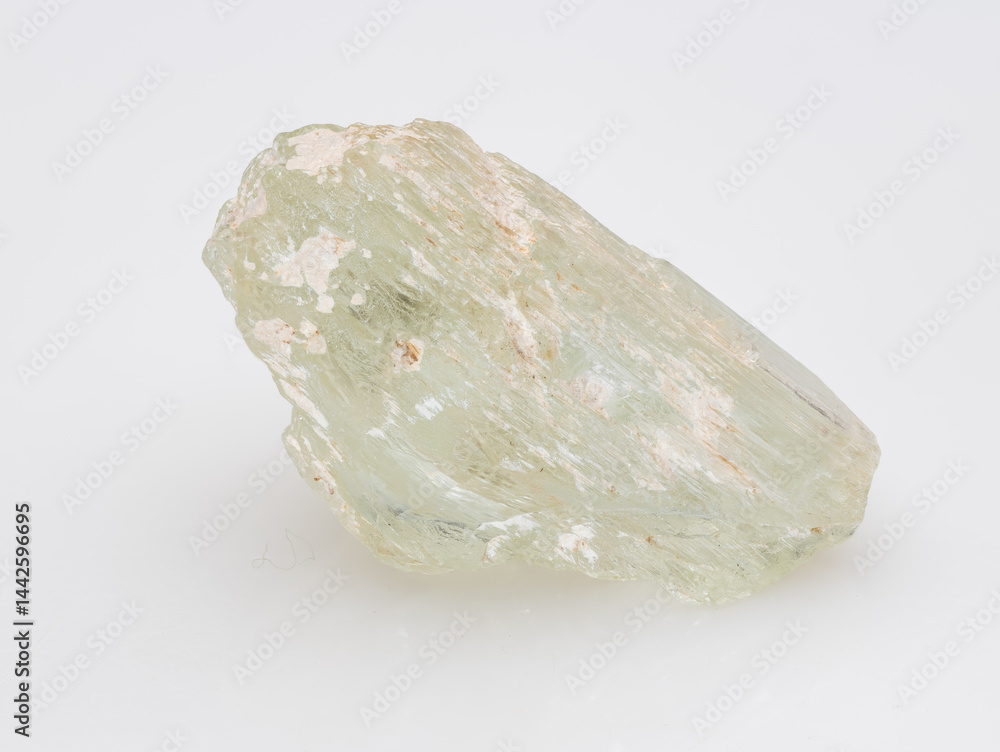 A raw, light green aquamarine crystal, a variety of beryl, showcases its prismatic shape with visible inclusions and a pale, milky hue on a clean white surface mineral specimen