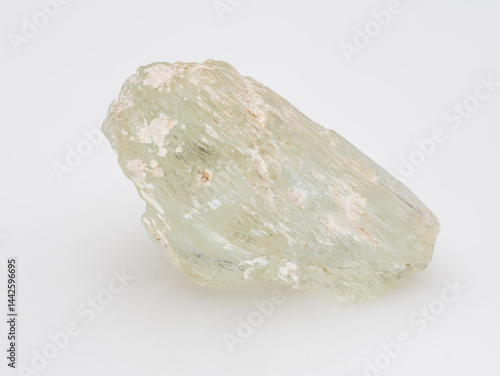 Obraz na płótnie A raw, light green aquamarine crystal, a variety of beryl, showcases its prismatic shape with visible inclusions and a pale, milky hue on a clean white surface mineral specimen w salonie