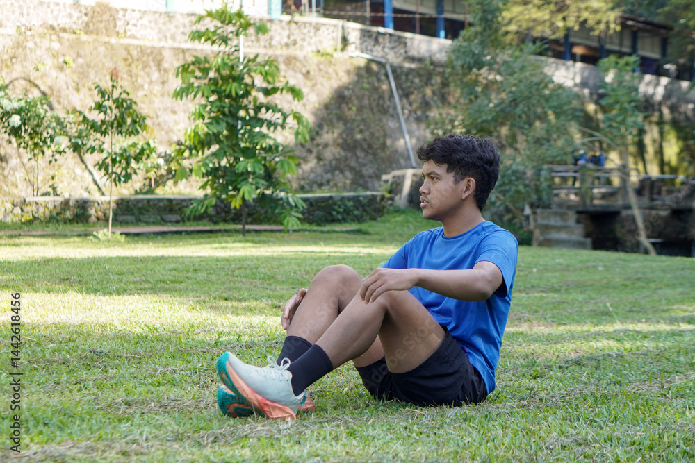 Fototapeta premium Portrait of Asian man in city park after jogging