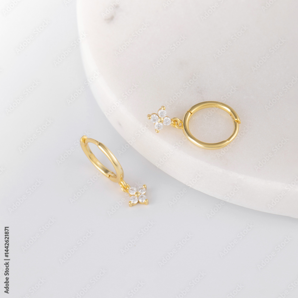 Elegant gold hoop earrings with star pendants on white background Elegant gold hoop earrings with star pendants on white background