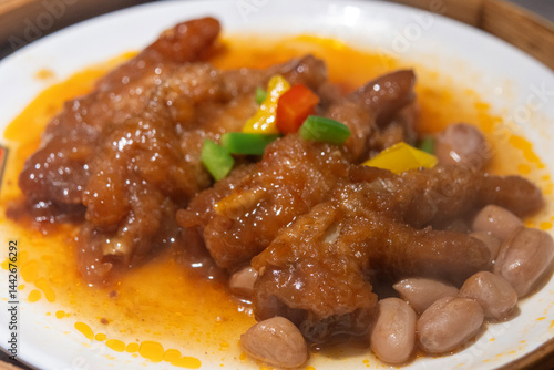 Braised chicken feet dim sum served on a bamboo steamer