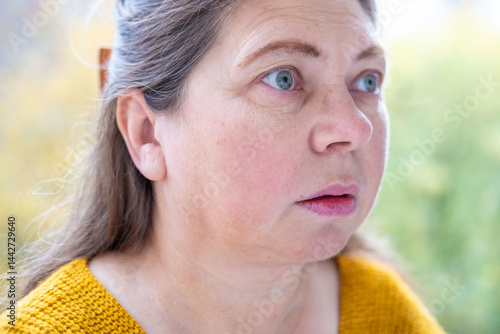 middle-aged mature woman with bulging eyes, face close-up, goggle eyes in fright, startled and scared expression, intense reaction conveying shock and fear