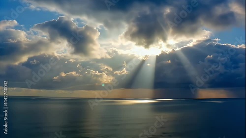 Sun Rays Break Through Clouds Over Calm Ocean