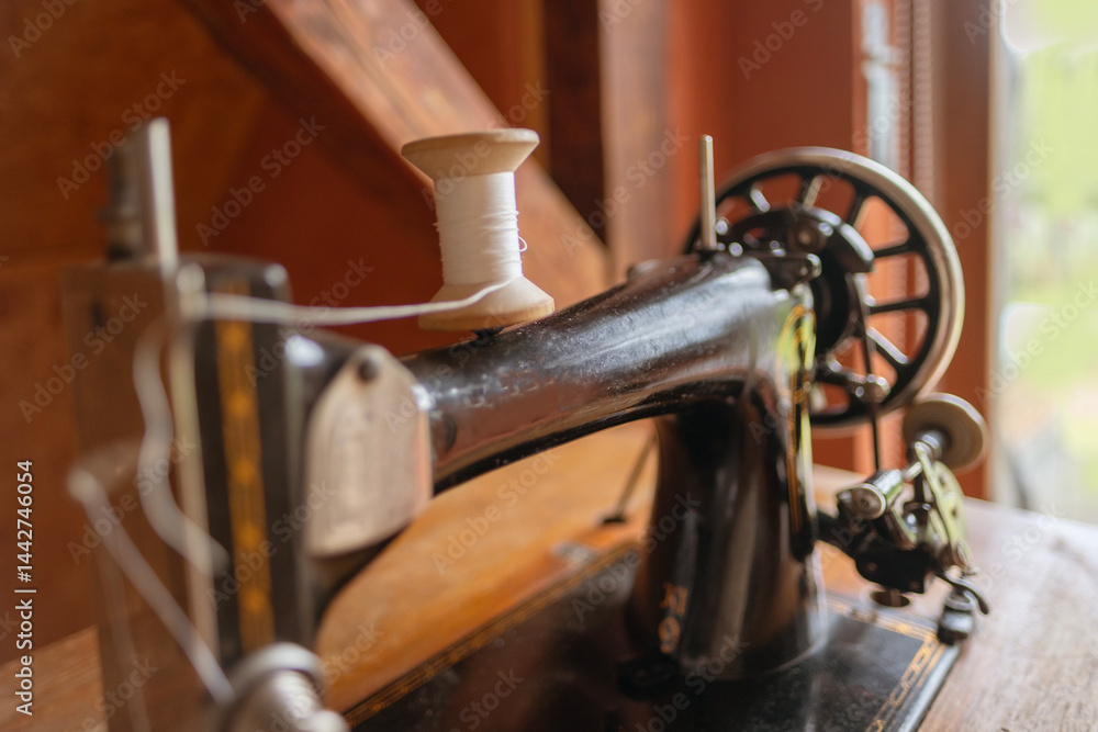 Fototapeta premium Vintage black sewing machine detail, retro craftsmanship, old technology, mechanical parts, historical object, sewing and tailoring