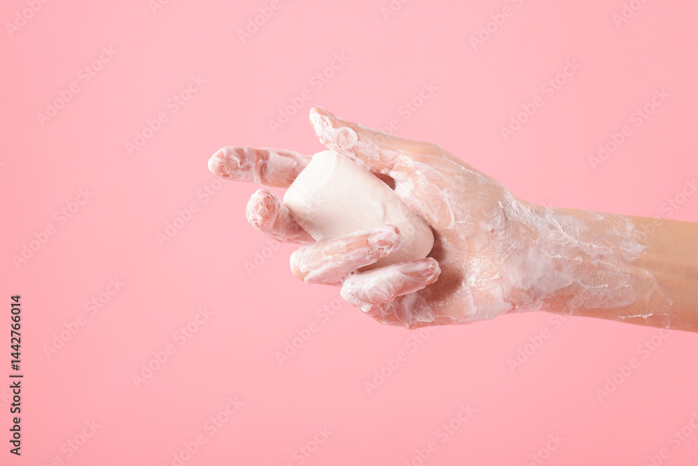 Fototapeta premium Woman washing hands with soap on light pink background, closeup