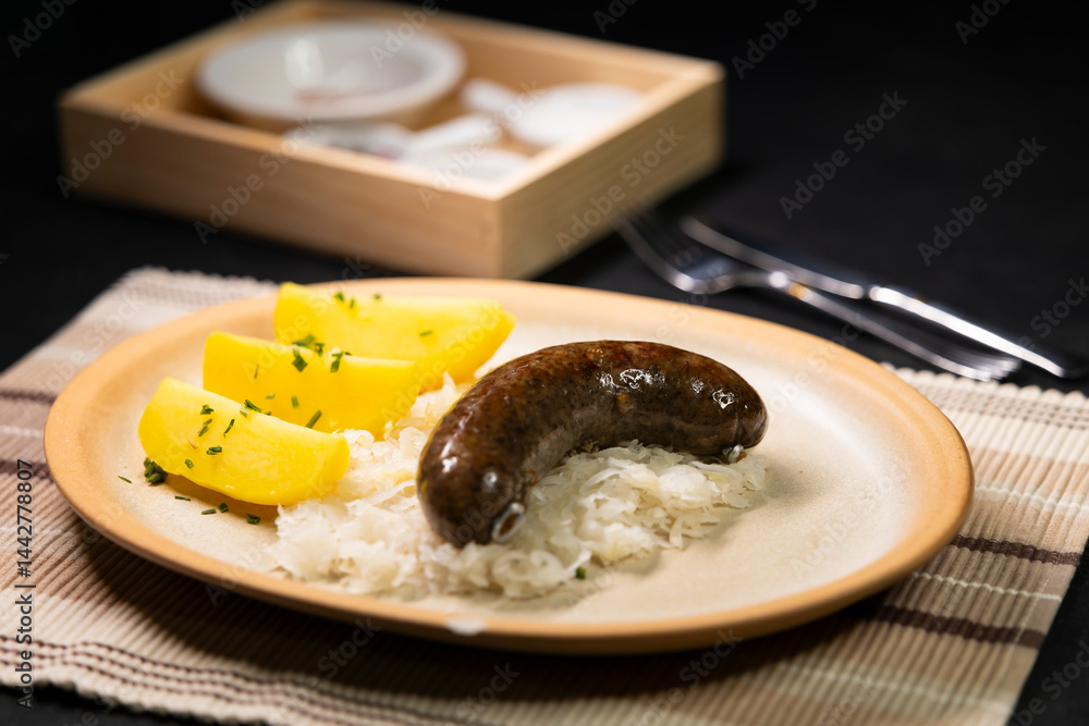 Bavarian blood sausage with sauerkraut and potatoes lying on a plate