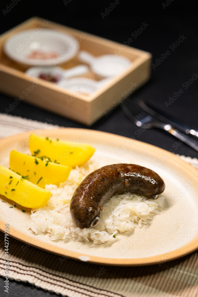 Bavarian blood sausage with sauerkraut and potatoes lying on a plate