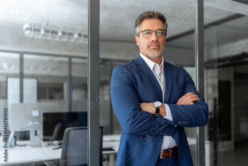 Executive confident senior business man specialist looking at camera. Portrait of mature professional boss, leader, ceo, male bank manager businessman in suit standing in office workplace. Copy space