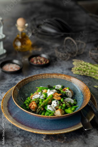 Obraz na płótnie Delicious chicken salad with green peas, asparagus and yogurt sauce, garnished with black sesame seeds w salonie