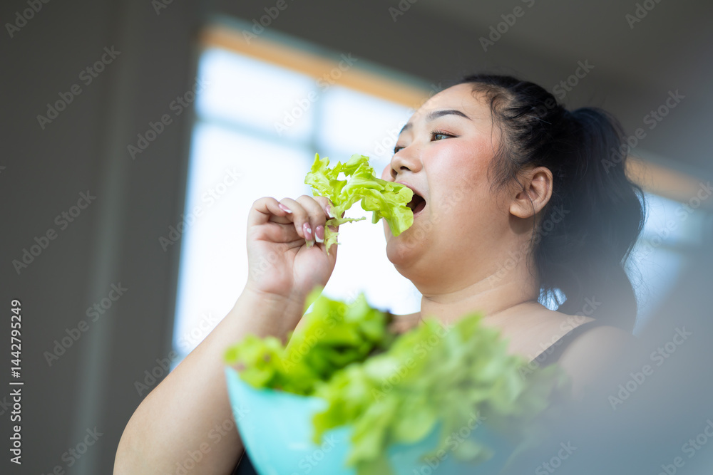 enjoying tasty vegetable salad. beautiful young chubby overweight woman wearing sporty fitness clothes doing exercise indoors at gym fitness sport club, body and health care