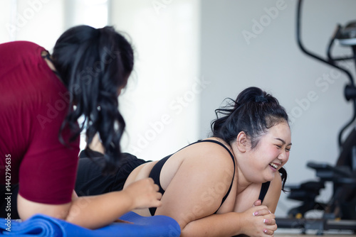 Obraz na płótnie Tired fat asian woman lies on floor gym. beautiful young chubby overweight woman wearing sporty fitness clothes doing exercise indoors at gym fitness sport club, body and health care w salonie