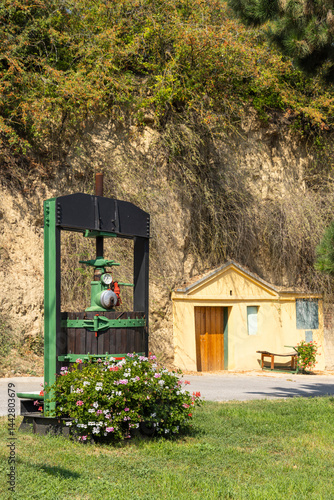 Obraz na płótnie Traditional wooden wine press standing in front of a wine cellar entrance w salonie