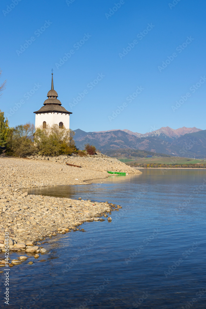 Liptovska Mara reservoir with the church tower of the flooded village and the Western Tatras in background