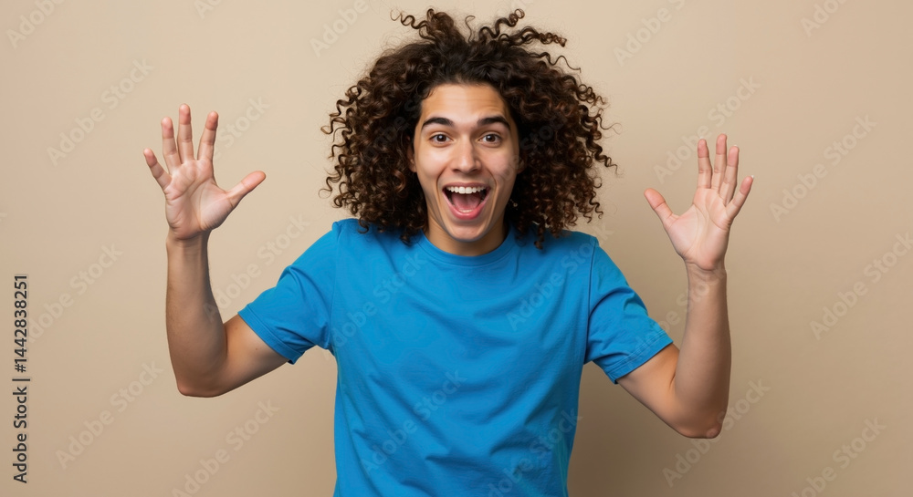 Caucasian young man with curly hair in blue t-shirt smiling, arms raised, beige background. Joy, happiness, lifestyle, motivation, sale, celebration, event, horizontal banner Caucasian young man with curly hair in blue t-shirt smiling, arms raised, beige background. Joy, happiness, lifestyle, motivation, sale, celebration, event, horizontal banner
