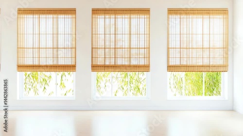 Three large windows with bamboo blinds allow soft light into a bright, minimalist room with leafy greenery visible outside.