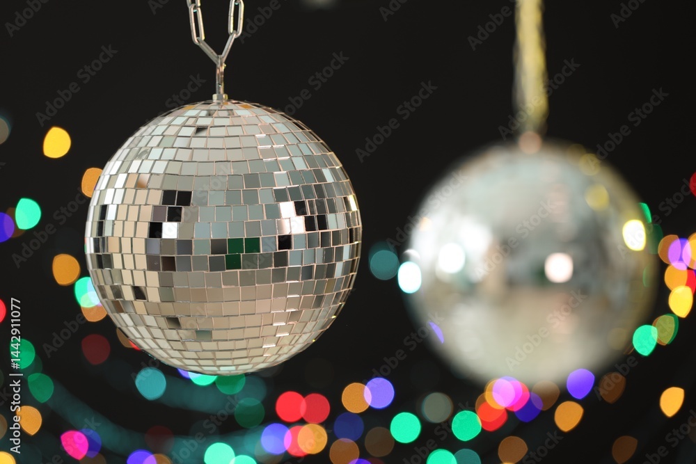 Obraz premium Shiny disco ball on black background with blurred lights
