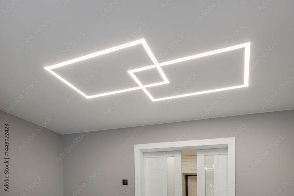 suspended ceiling with halogen spots lamps in form of squares and rectangles and drywall construction in empty room in apartment or house. Stretch ceiling white and complex shape.