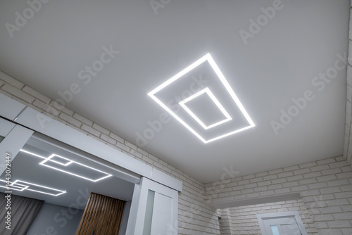 Obraz na płótnie suspended ceiling with halogen spots lamps in form of squares and rectangles and drywall construction in empty room in apartment or house. Stretch ceiling white and complex shape. w salonie