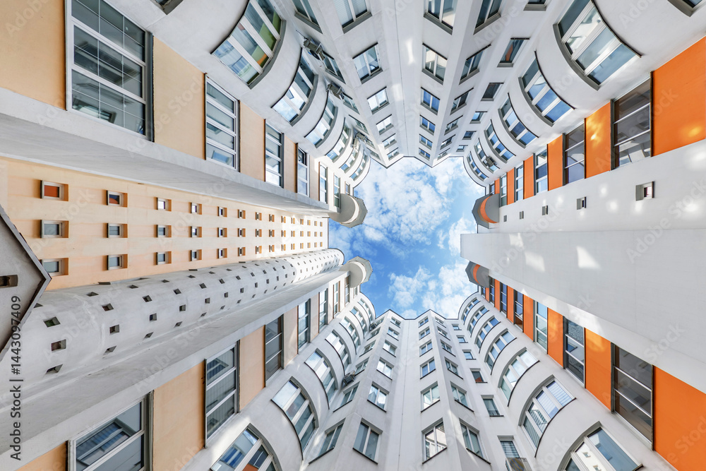 view from bottom up to the sky in a skyscraper house well with a narrow yard