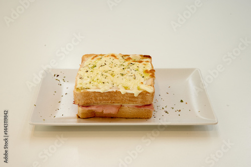 Obraz na płótnie A sandwich with cheese on top of it. The sandwich is cut in half. The cheese is melted w salonie