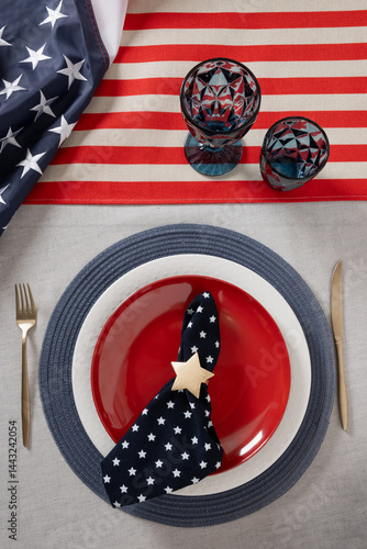 Obraz na płótnie Table setting for USA Independence Day. Festive dinner with red plate and decoration in USA national flag colors and stars. Copy space. Vertical. View from above w salonie