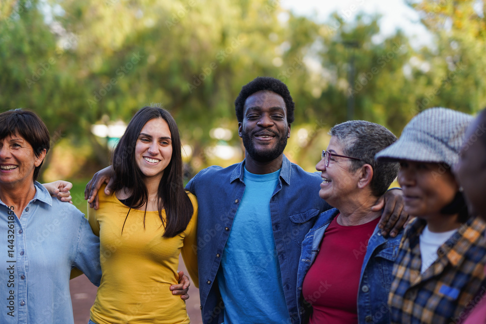 Multi generational diverse people hugging each other at city park - Multiracial community and social inclusion concept Multi generational diverse people hugging each other at city park - Multiracial community and social inclusion concept