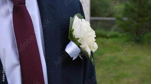 a flower is an ornament on a man's costume in the form of a boutonniere