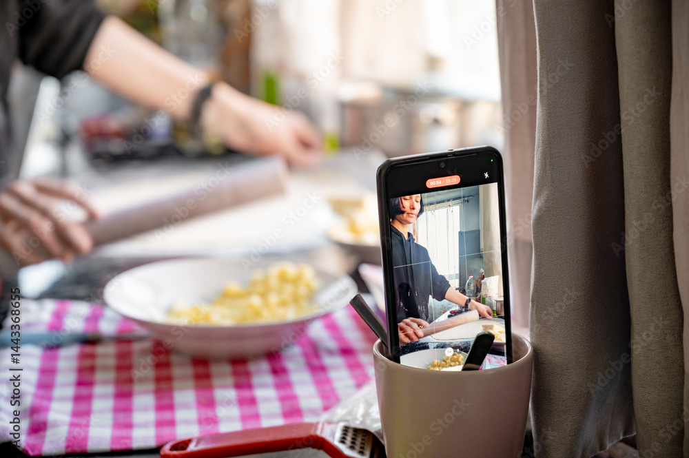 Filming on a phone as a girl cooks pizza. Home shooting. Video content for social networks.