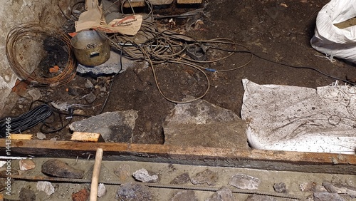 Fotografi Renovation project reveals uneven floor with exposed dirt and debris in a baseme