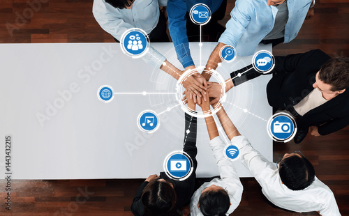A top view of diverse hands stacking together, surrounded by digital media icons, symbolizing collaboration, innovation, and strong connections in a modern work environment. Amity