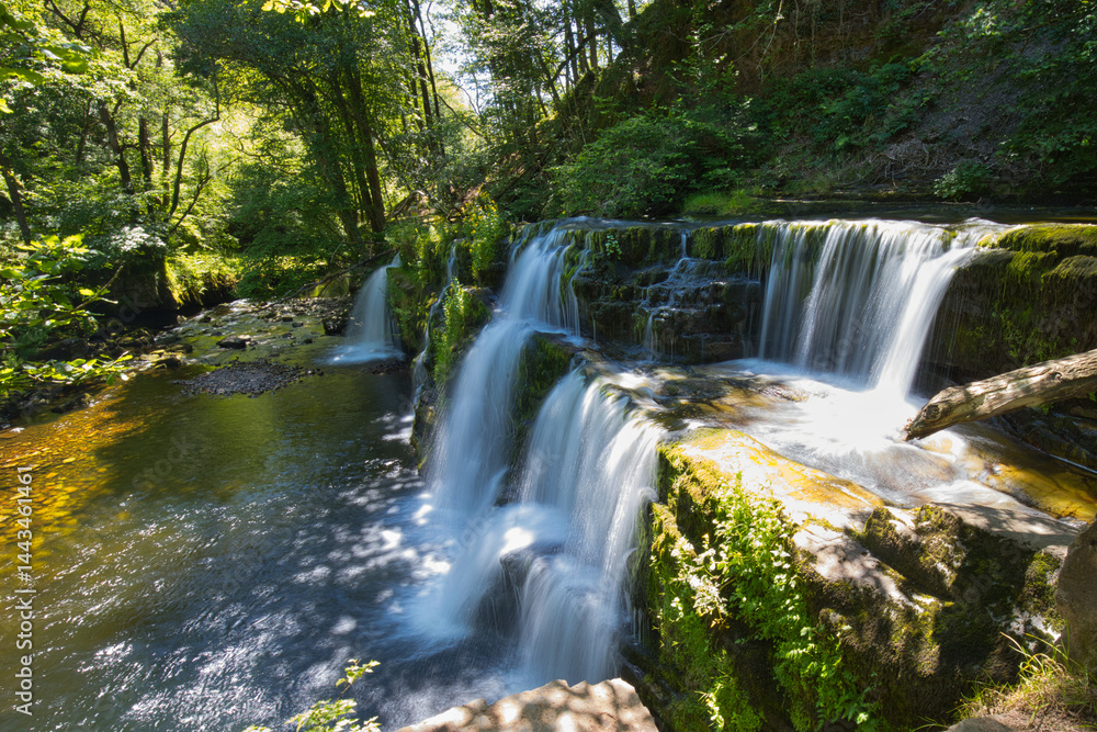 Obraz premium The waterfall Sgwd Isaf Clun-Gwyn at the Four Waterfall Walking Trail in the Brecon Beacons in South Wales.