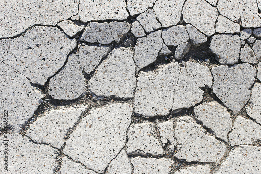 Cracked concrete surface. Urban damage texture. Broken asphalt closeup. Grey rough pattern. Destruction background. Street detail. Weathered cracked ground. Cement break structure.