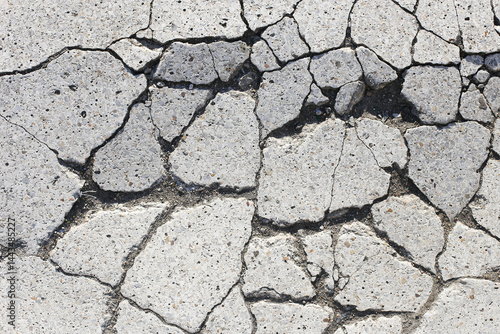 Cracked concrete surface. Urban damage texture. Broken asphalt closeup. Grey rough pattern. Destruction background. Street detail. Weathered cracked ground. Cement break structure.