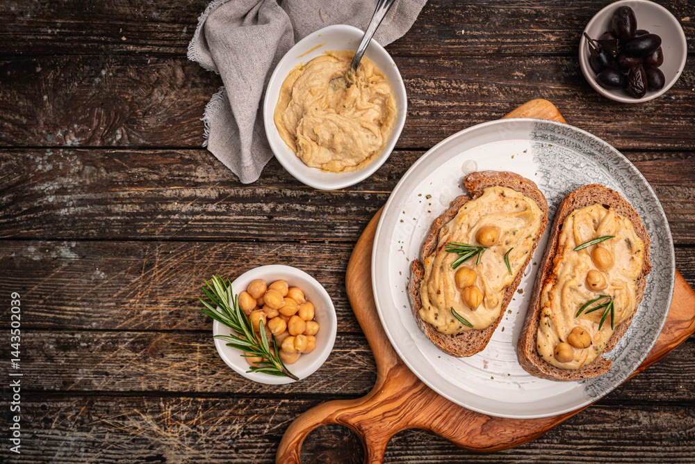 Delicious sandwiches with hummus and ingredients on a dark wooden background, top view, flat lay. High quality photo