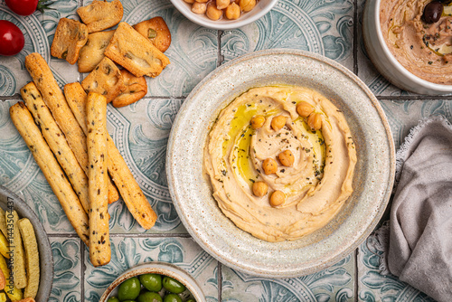 Obraz na płótnie Various hummus dips in different colours. Hummus with dry crackers, top view. Vegan and traditional hummus as healthy and vegan snack. w salonie