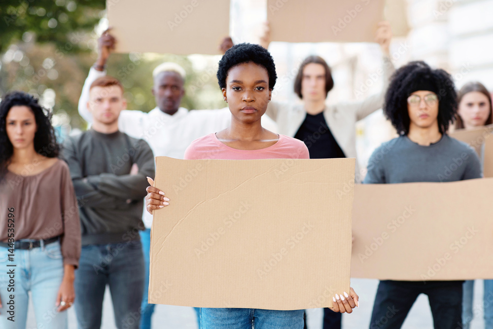 African american young woman leading a group of demonstrators on the street. International diverse group of people with empty placards protesting for human or animal rights and against racism African american young woman leading a group of demonstrators on the street. International diverse group of people with empty placards protesting for human or animal rights and against racism
