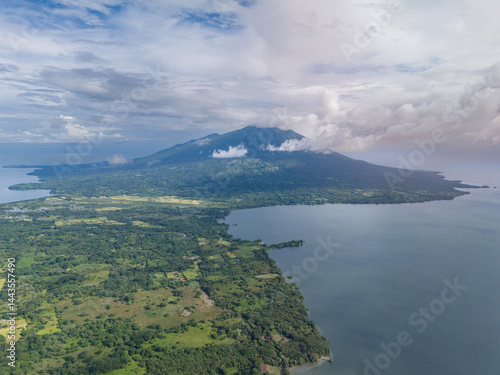Obraz na płótnie Aerial view of lush landscape featuring volcano near tranquil lake on a cloudy day w salonie