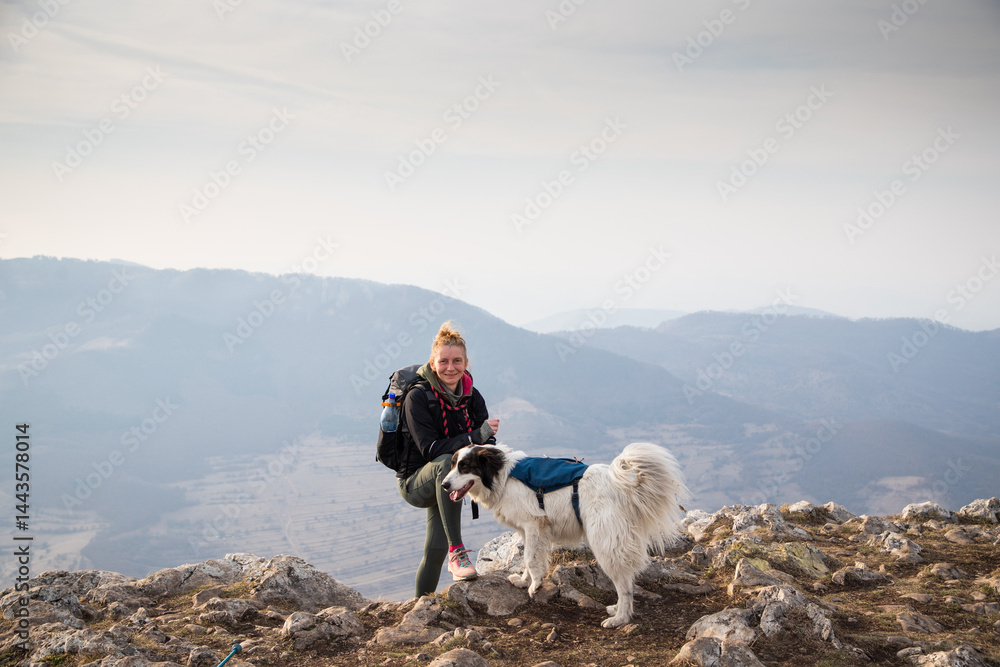 happy fit woman trekking with her dog