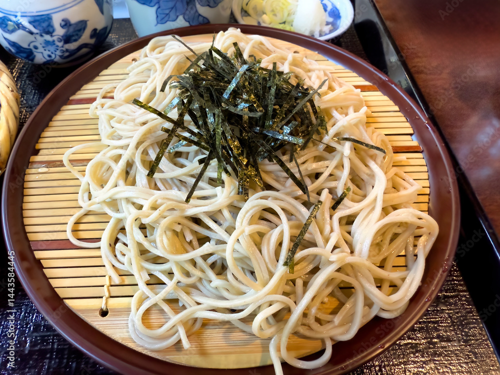 Asian soba noodle and seaweed on bamboo dish platter in top view